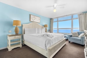 Wake up to breathtaking ocean views from your comfortable bed. Soft blue walls and coastal furnishings create a serene retreat.