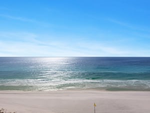 Pristine beach with crystalclear turquoise waters and soft white sand stretches endlessly under brilliant blue skies.