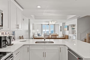 Your bright, modern kitchen flows seamlessly into the living area, where stunning gulf views await through floortoceiling windows.