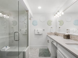 Unwind in your coastalinspired bathroom with glassenclosed shower, elegant dual vanity, and charming seathemed touches.