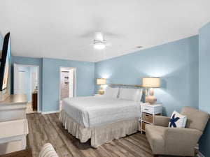 Unwind in your serene bedroom with calming blue walls, plush bedding, and warm lighting that creates the perfect peaceful retreat.