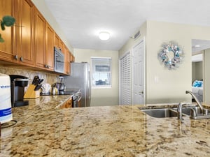 Your fully equipped kitchen features granite countertops, stainless steel appliances, and warm wood cabinetry perfect for preparing memorable meals.
