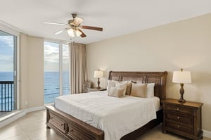 Bedroom 1 Wake up to stunning beach views in this serene bedroom with private balcony access.