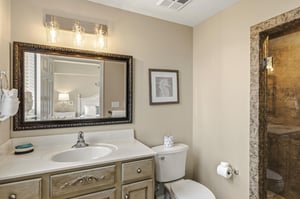 Bathroom 2 featuring elegant vanity lighting and a spacious tiled shower for relaxing after your adventures.