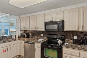 Your fully equipped kitchen features granite counters, stainless appliances, and stunning ocean views.
