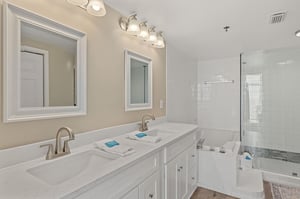 Bathroom 1 with dual vanities, marble counters, and a glassenclosed shower for ultimate relaxation.