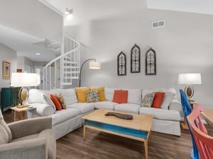 Unwind in this bright, spacious living room with plush sectional seating and colorful accents that create the perfect atmosphere for relaxation.