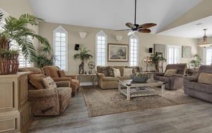 Settle into this spacious living room where tropical plants and comfortable seating create your perfect retreat for relaxation.