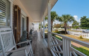 Your wraparound porch invites you to relax in rocking chairs while enjoying peaceful neighborhood views and tropical breezes.