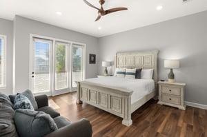 Bedroom 1 is a sanctuary with luxurious linens, a cozy reading chair, and French doors opening to a Balcony