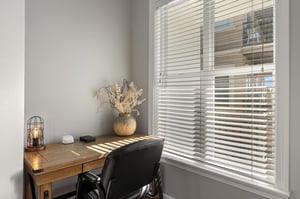 Private workspace with wooden desk, stylish lighting, and natural light filtering through blinds for productive days.