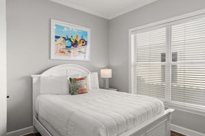 Drift off in the serene coastal bedroom, where soft gray walls and beachthemed artwork create the perfect retreat after a day of adventures.