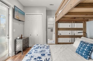 The nauticalthemed bedroom features a cozy bunk bed with custom wood beams, perfect for families or groups sharing adventure.