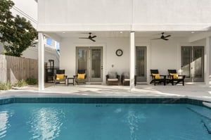 Your private pool beckons with crystalclear waters, while comfortable lounge chairs await under covered patio with ceiling fans for perfect relaxation.