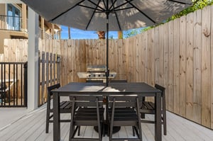 Your private patio awaits with dining table, umbrella shade, and BBQ grill ready for memorable outdoor meals and relaxation.