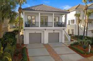 A pristine coastal property featuring Mediterraneanstyle architecture with palm trees and tropical landscaping in a peaceful residential setting.