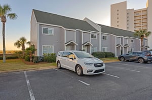 Multiunit vacation townhomes with convenient parking, nestled among palm trees in a peaceful coastal setting.