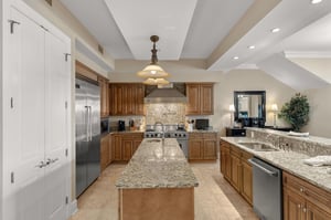 Prepare memorable meals in your fullyequipped gourmet kitchen featuring granite counters, premium appliances, and elegant exposed beams.