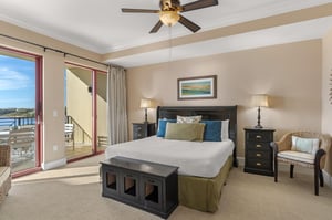 The spacious firstfloor king bedroom offers a serene retreat with a king bed, ceiling fan, and stunning balcony views.