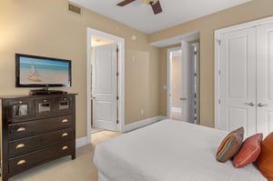 Unwind in your peaceful bedroom with oceaninspired decor, ceiling fan, and entertainment center for ultimate relaxation.