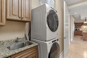 Your dedicated laundry space features modern washer and dryer with convenient granite countertop for folding and preparing clothes.