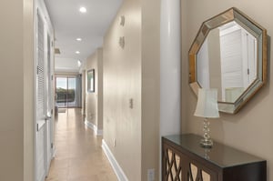 Step into your elegant hallway where natural light floods through, leading you toward your private balcony retreat.