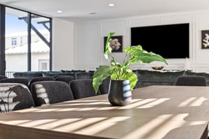 Gather around this beautiful dining table where sunlight streams through large windows, creating the perfect space for meals and conversations.