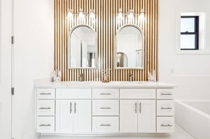 Indulge in luxury at your dualsink vanity with stunning wood slat accent wall and elegant lighting.