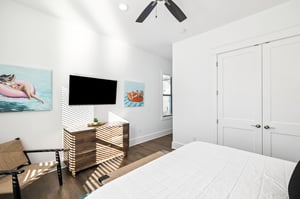 Drift off to sleep in your bright, airy bedroom where morning sun creates beautiful patterns across crisp linens and playful artwork sets a relaxed tone.