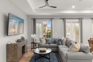 Relax in your stylish living room with plush sectional seating, modern entertainment setup, and peaceful views through large windows.