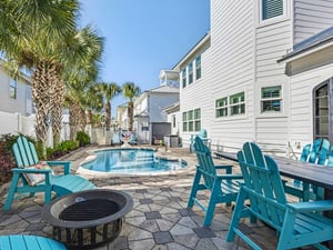 A private pool oasis surrounded by swaying palms and turquoise Adirondack chairs, where summer afternoons stretch endlessly.