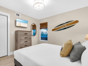 Drift off peacefully in your coastalthemed bedroom, complete with beach artwork and surfboard decor creating perfect vacation vibes.
