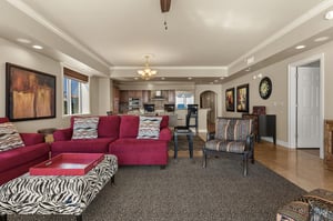 Settle into your stylish openconcept living space with plush burgundy sectional and vibrant patterns, flowing seamlessly into the gourmet kitchen.