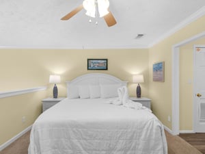 Your peaceful retreat awaits with crisp white linens, gentle bedside lighting, and a ceiling fan to keep you comfortable.