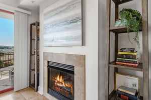 Cozy up by your private fireplace with a good book from the curated shelves, watching flames dance as natural light fills your stylish retreat.