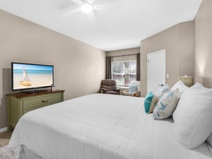 Sink into crisp white linens and unwind in your cozy bedroom, where nautical touches and a large TV create the perfect coastal retreat.