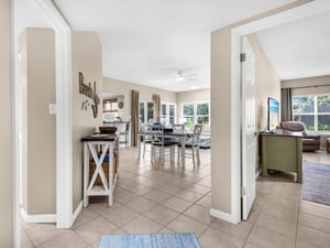 Step into your bright, open living space where coastal charm meets comfort—perfect for gathering around the dining table.