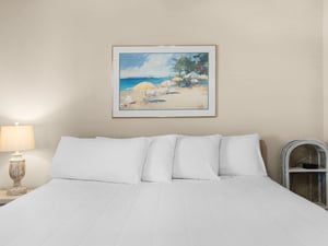 Sink into crisp white linens beneath coastal artwork that brings ocean breezes into your peaceful retreat.