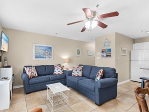 Unwind in the living room with navy seating and cheerful coastal art that sets the perfect beach vacation mood.