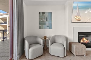 Unwind in your private seating area where modern comfort meets coastal charm, complete with a cozy fireplace for perfect evening relaxation.