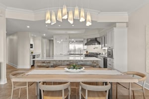 Your openconcept kitchen and dining space features elegant pendant lighting, modern appliances, and a warm wood table perfect for memorable meals.