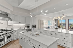 Your spacious gourmet kitchen features gleaming white cabinetry, premium appliances, and stunning views through floortoceiling windows.