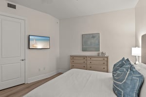 Drift off in your serene bedroom featuring coastal artwork and soft bedding that invites peaceful sleep.