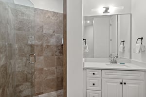 Your private bathroom features elegant stonetiled shower and modern vanity for refreshing starts to your days.