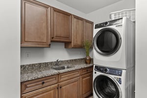 Your private laundry room features granite countertops, ample cabinet storage, and a builtin sink for easy garment care.