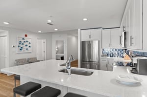 Sleek white cabinets and blue mosaic backsplash make cooking more fun