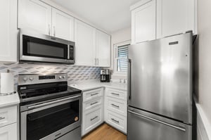 The fully equipped kitchen features sleek stainless steel appliances and bright white cabinets, perfect for preparing meals during your stay.