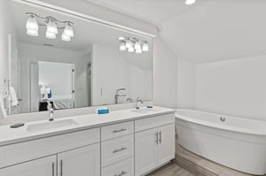 The ensuite bath features dual vanities and a relaxing soaking tub.