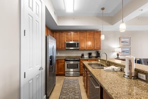 This fully equipped kitchen features granite countertops, stainless steel appliances, and warm wood cabinets for memorable meals.