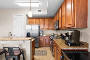 Fully equipped kitchen welcomes you with warm wood cabinetry, granite countertops, and stainless steel appliances—perfect for preparing memorable meals.